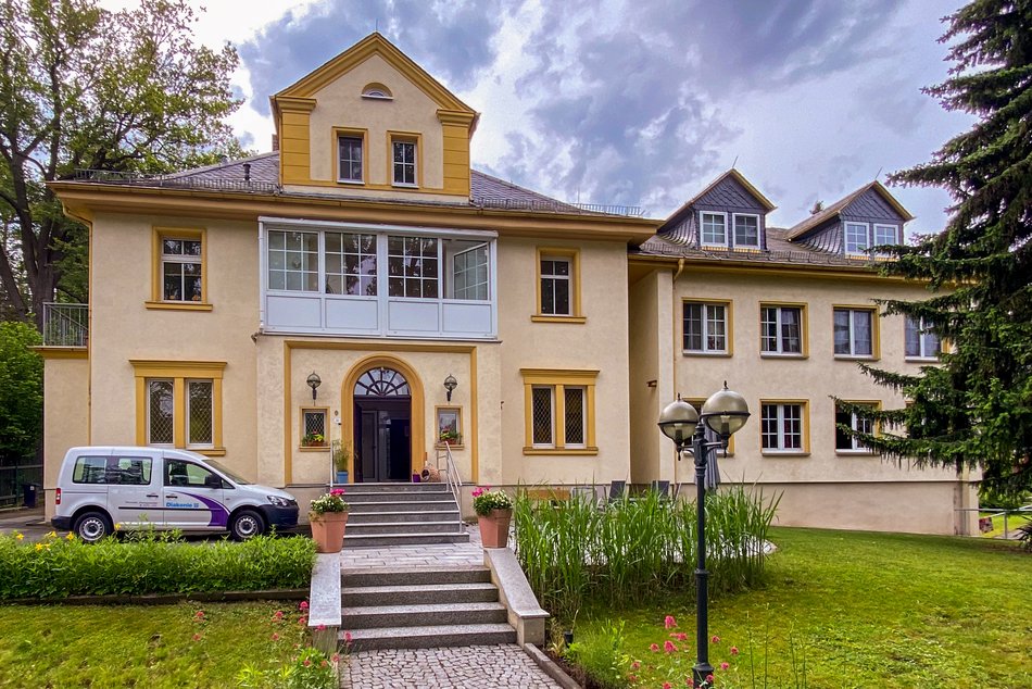 zwei Mitarbeiter stehen vor dem Eingang zur Wohnstätte Plantagenstraße