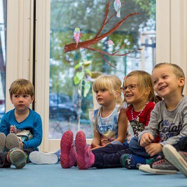Mehrere Kinder mit ihrer Erzieherin beim Morgenkreis