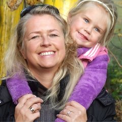 Eine lächelnde Mutter hat ihre Tochter auf den Schultern