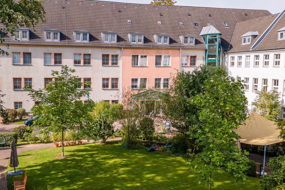 Blick auf das Marthaheim mit grüner Außenanlage im Vordergrund