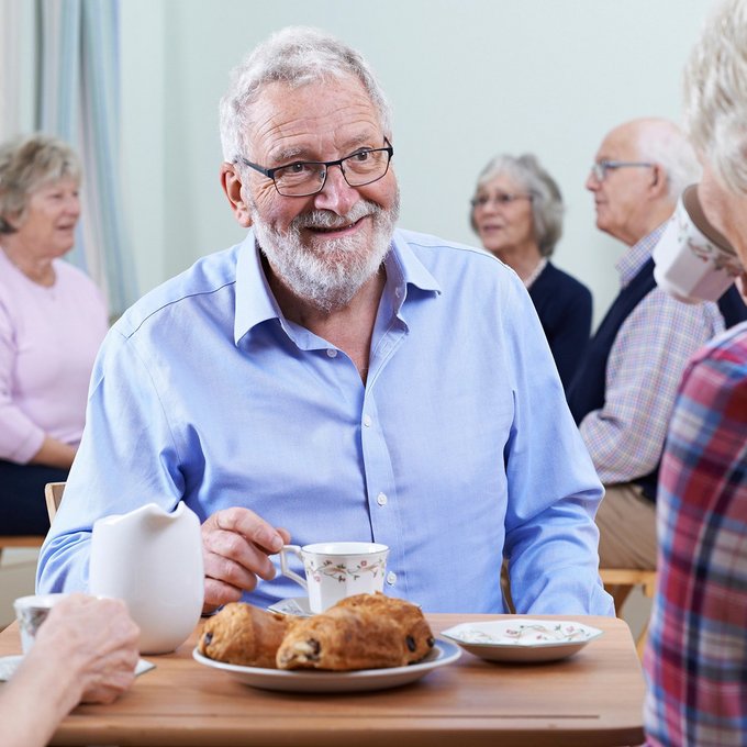 Drei Angehörige am Kaffeetisch sind in ein Gespräch vertieft.