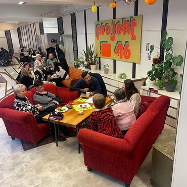 Kulturcafe.jpg Menschen verschiedener Kulturen sitzen an einem Cafétisch und unterhalten sich