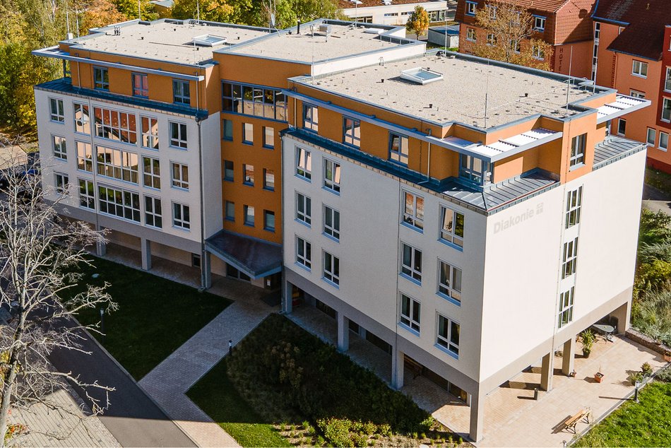 Luftbild vom Haus Wettiner Straße, der moderne Neubau hat eine beige Fassade und Laternengeschoss mit orangem Anstrich