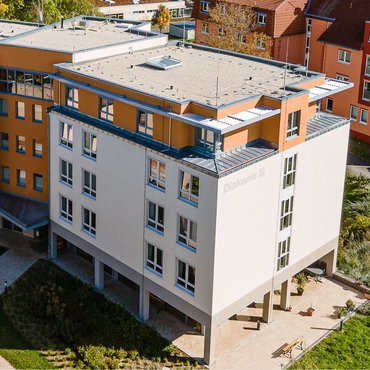 Luftbild des Haus Wettiner Straße Luftbild vom Haus Wettiner Straße, der moderne Neubau hat eine beige Fassade und Laternengeschoss mit orangem Anstrich