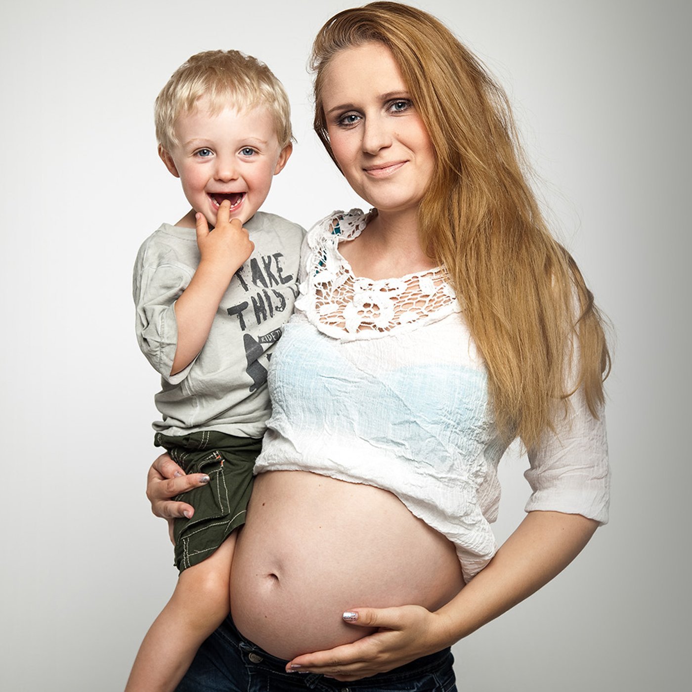 Junge Frau mit einem fröhlichen Jungen auf dem Arm
