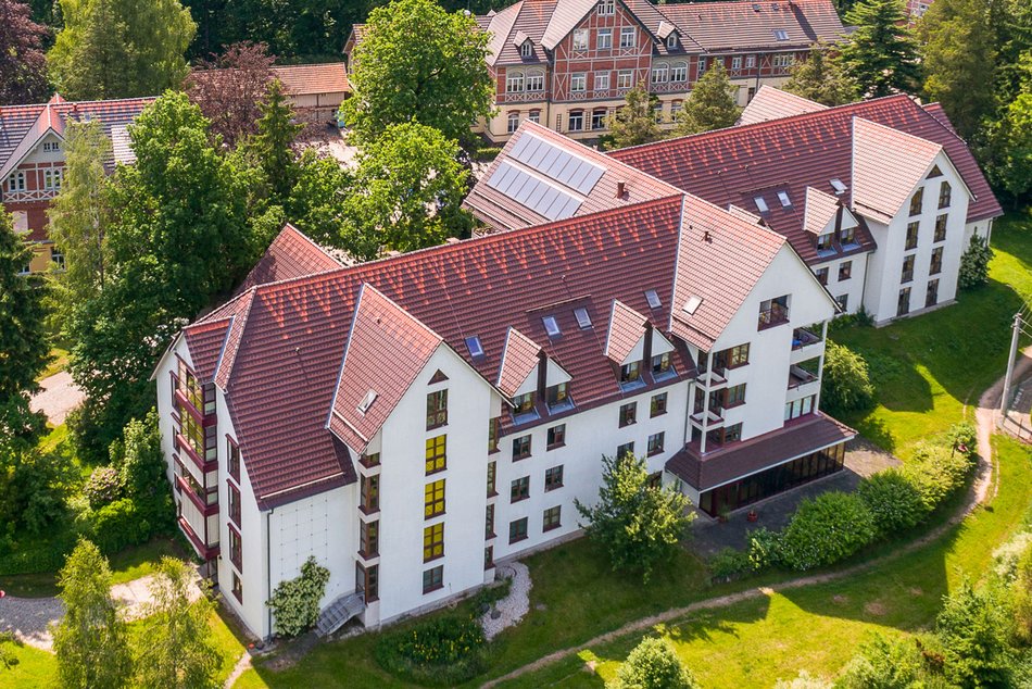 Luftbild vom Bethlehemstift mit dem Haus Jahreszeiten im Vordergrund, das Gebäude hat eine weiße Fassade und ein rotes Ziegeldach 