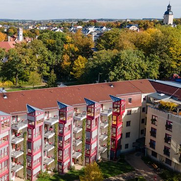 Luftbildaufnahme vom Haus Heinrichshof in Glauchau Luftbild des Haus Heinrichshof, an der Fassade sind zahlreiche kleine Balkone und Wintergärten der Bewohnerzimmer zu sehen, im Hintergrund ist Glauchau mit Schloss und Kirche zu sehen
