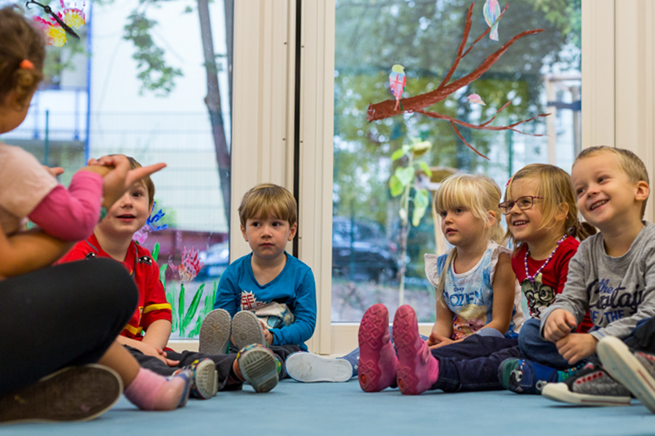 Mehrere Kinder mit ihrer Erzieherin beim Morgenkreis